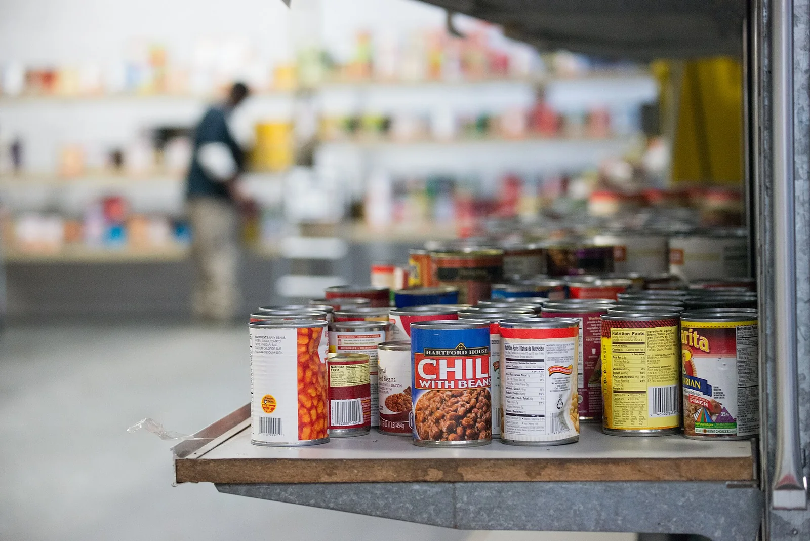 Shelves of donated tinned food ready to be packed at a community food bank